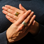 Load image into Gallery viewer, Close-up of hands with gold rings on a dark background
