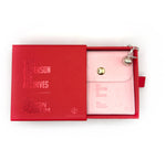 Load image into Gallery viewer, Pink wallet with gold clasp and silver charm in a red box, featuring 'The Design Museum' branding.
