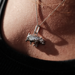 Load image into Gallery viewer, A close-up lifestyle shot of a person's chest wearing a silver Rhino pendant necklace on a fine chain.
