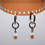 Load image into Gallery viewer, Silver hoop earrings with a pearl hanging from a roll of celluloid film.
