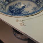 Load image into Gallery viewer, A silver chain necklace with a single white pearl and a matching pearl stud earring, displayed on a white surface next to a blue and white ceramic bowl.
