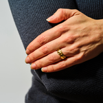 Load image into Gallery viewer, Hand wearing a gold ring with a plain background

